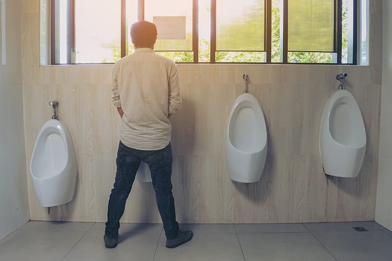 Man standing at a urinal