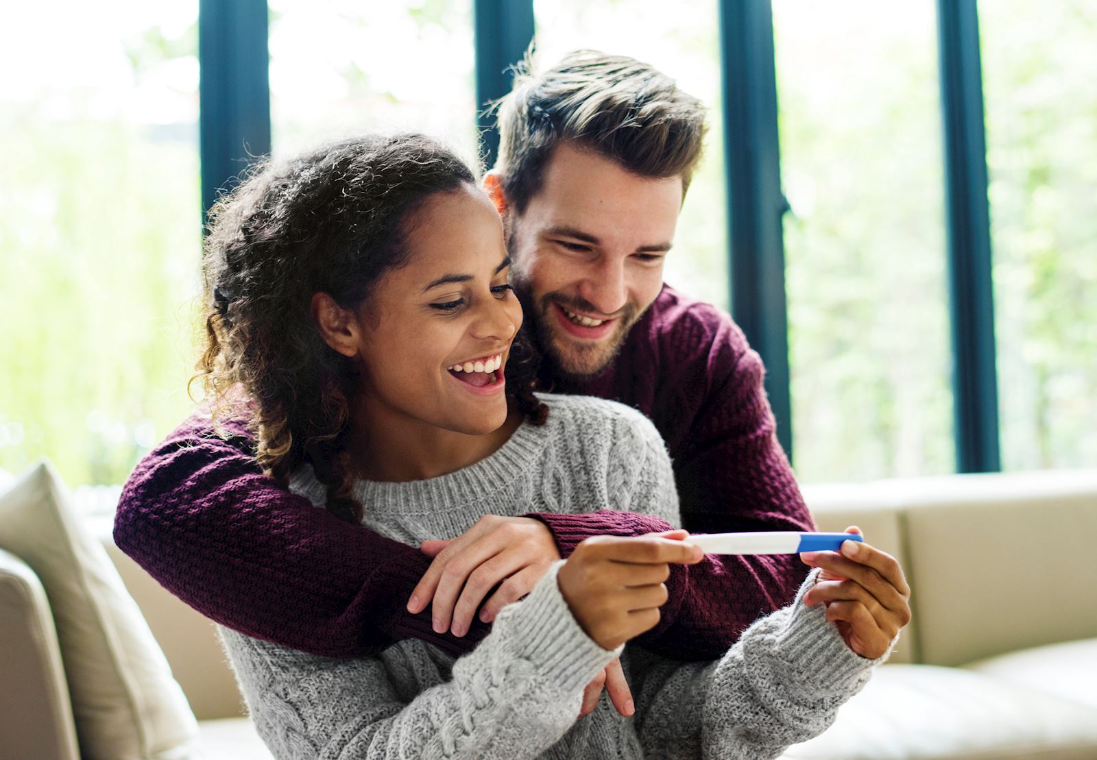 couple looking at pregnancy test smiling