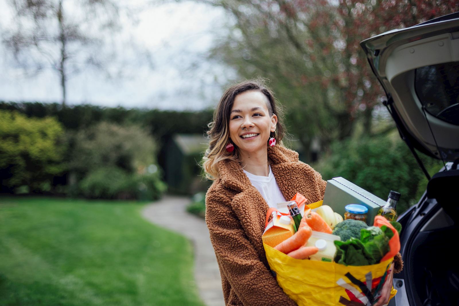 woman carrying in groceries from her car