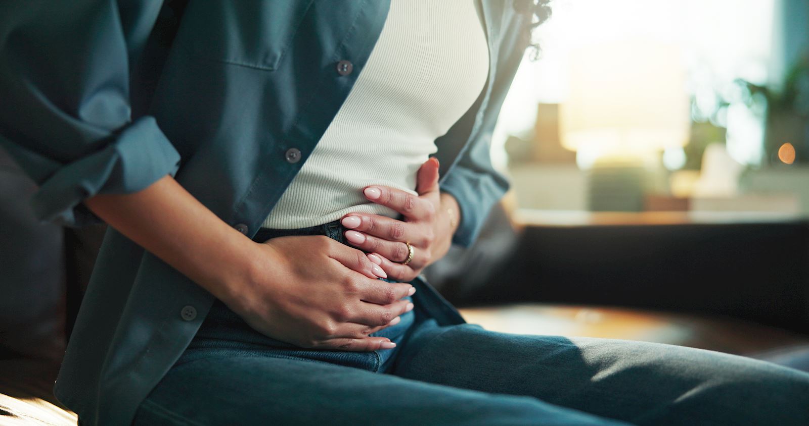 woman sitting down holding her abdomen