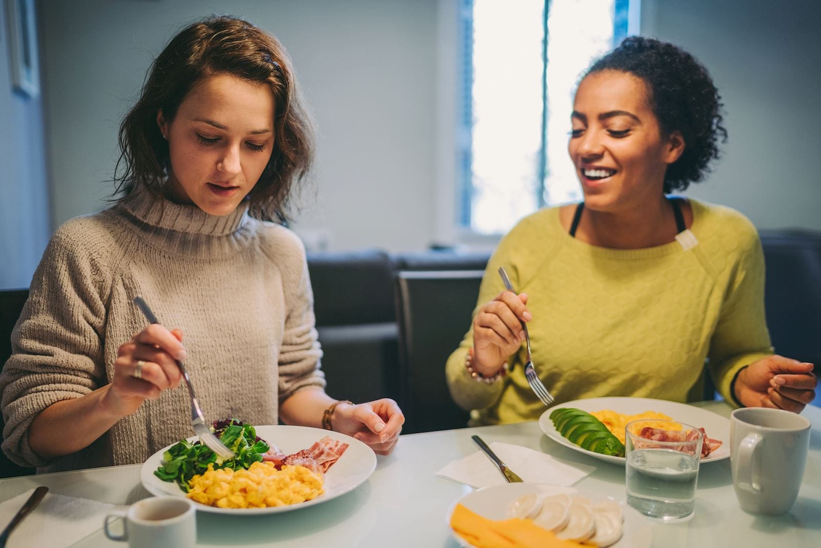 two women sitting at the table eating