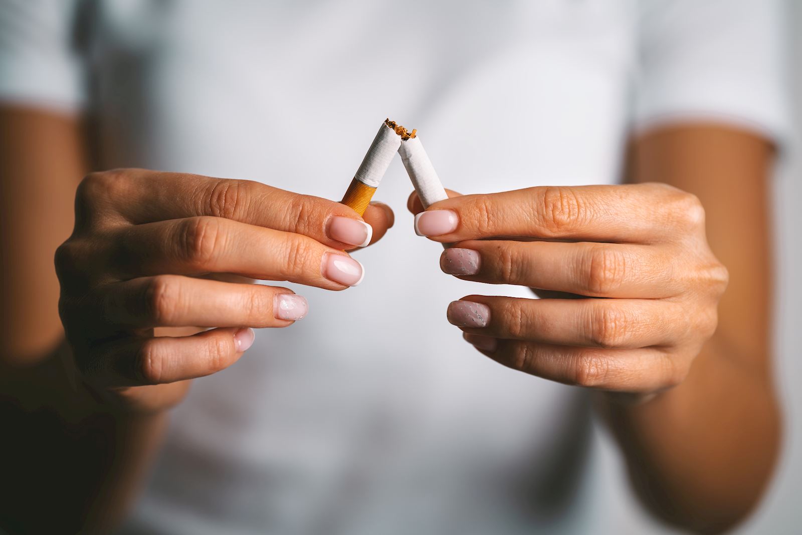 woman breaks cigarette in half