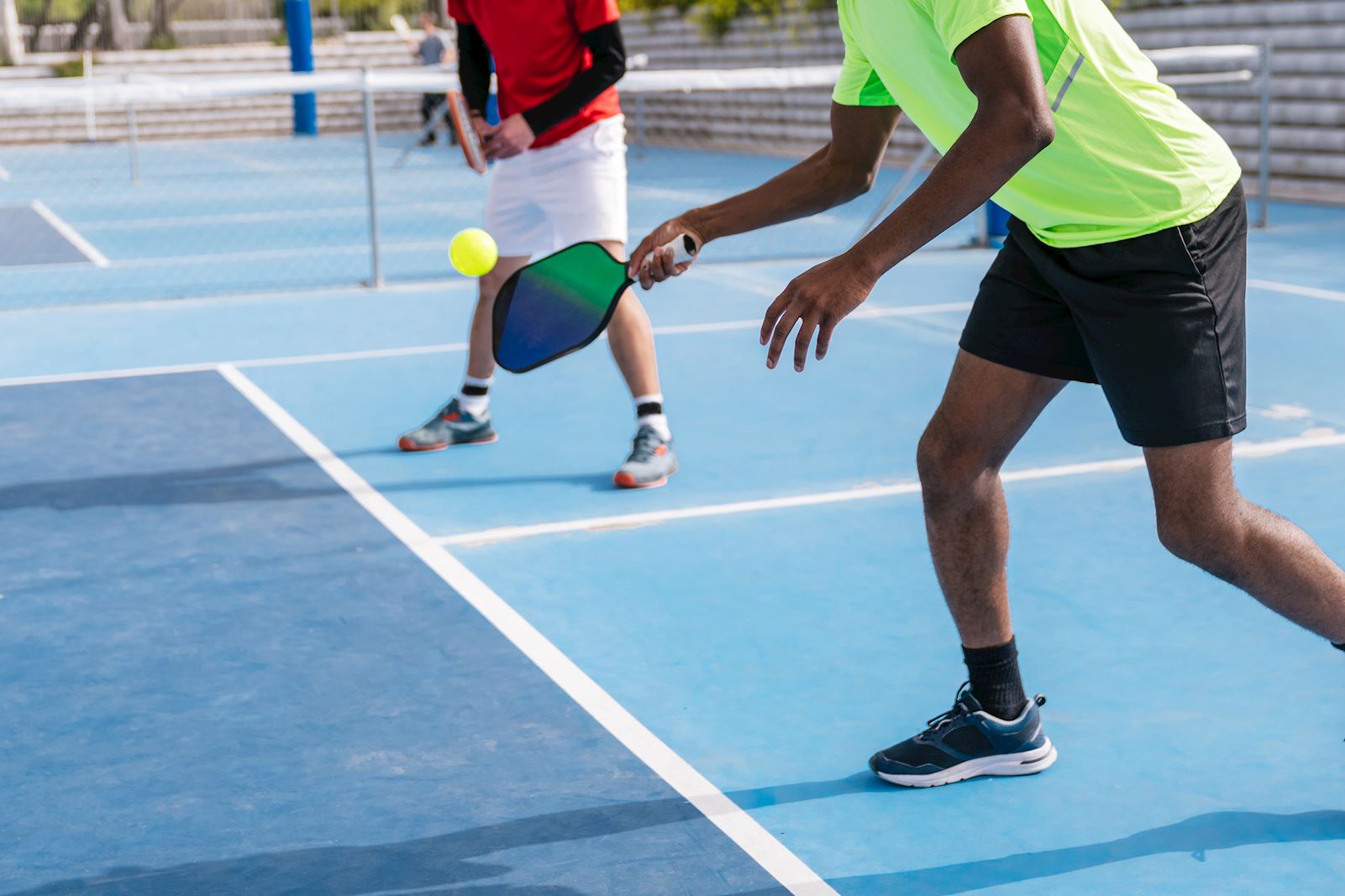 two people playing pickleball outside