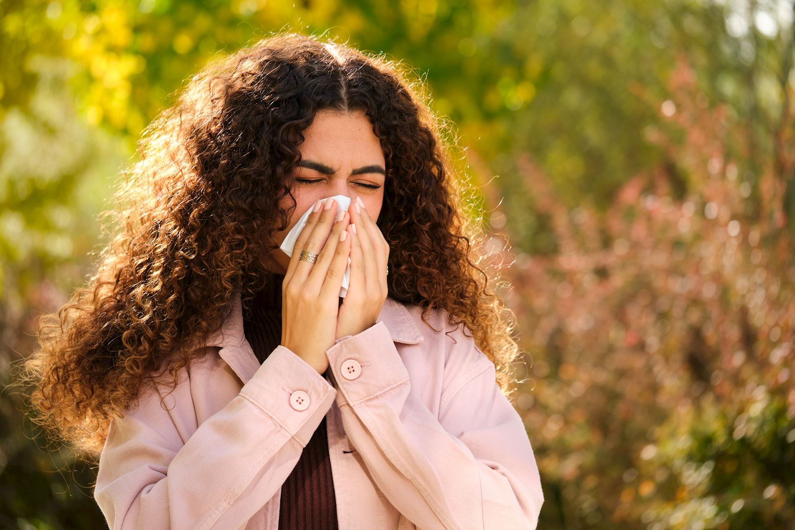 woman outside sneezing