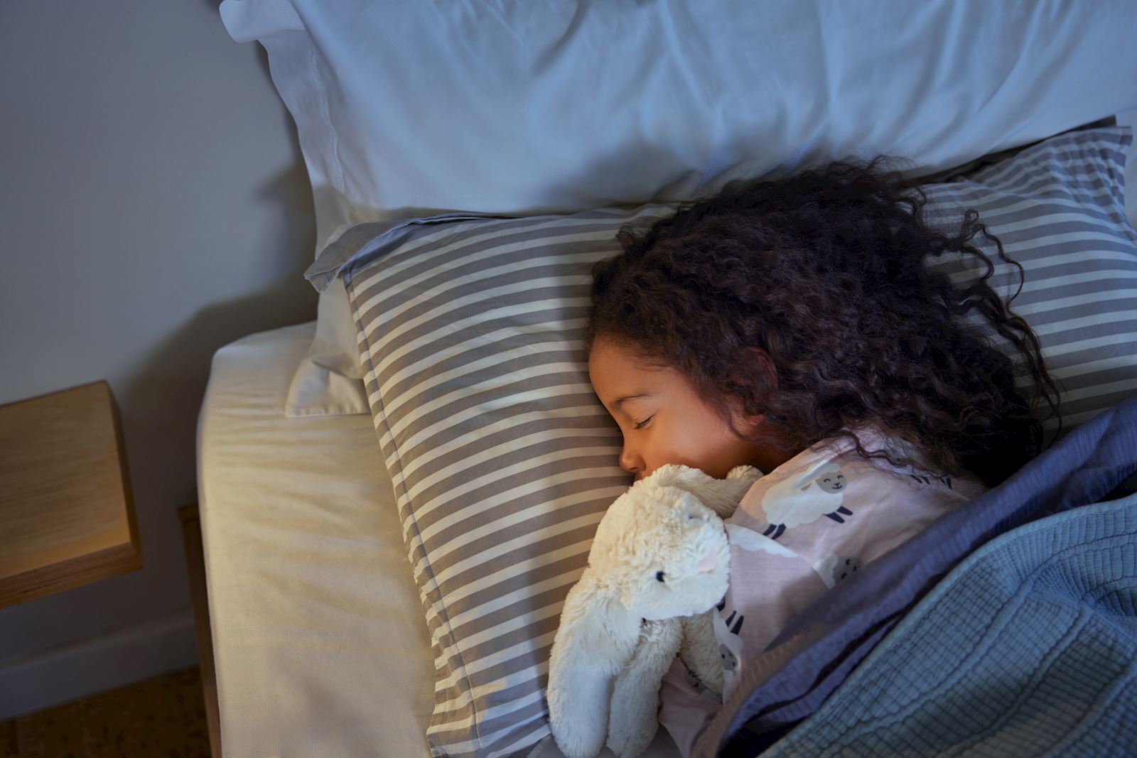 child sleep in bed with stuffed animal