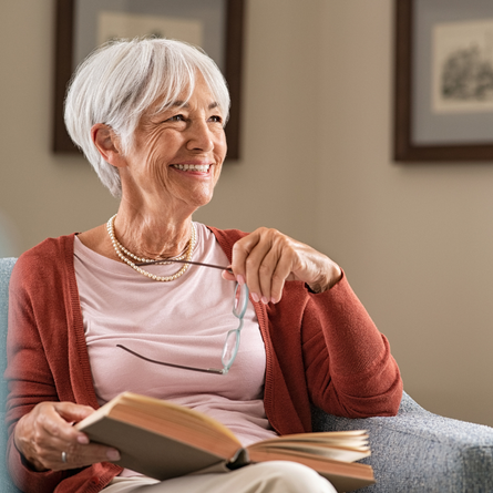 Woman with glasses on couch smiling