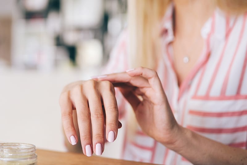 Woman putting moisturizer on her hands
