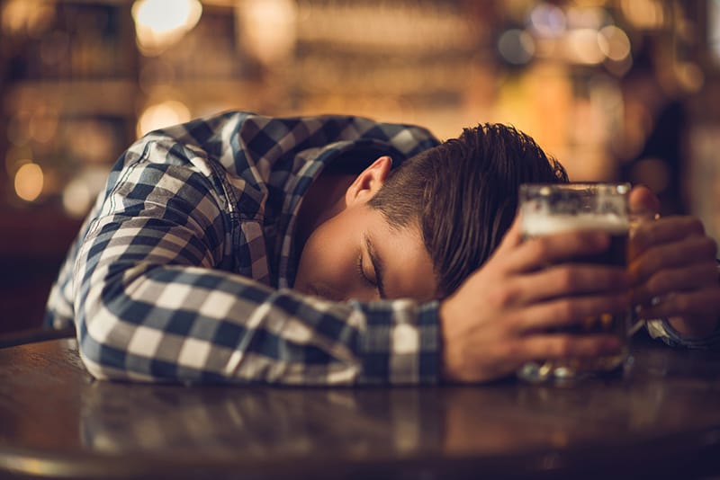 Person passed out holding a beer