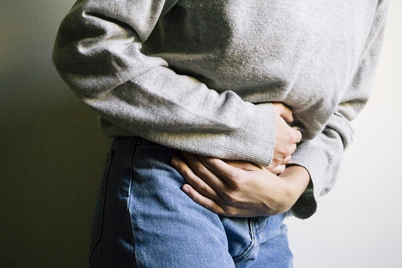 Women holding her stomach from endometriosis pain