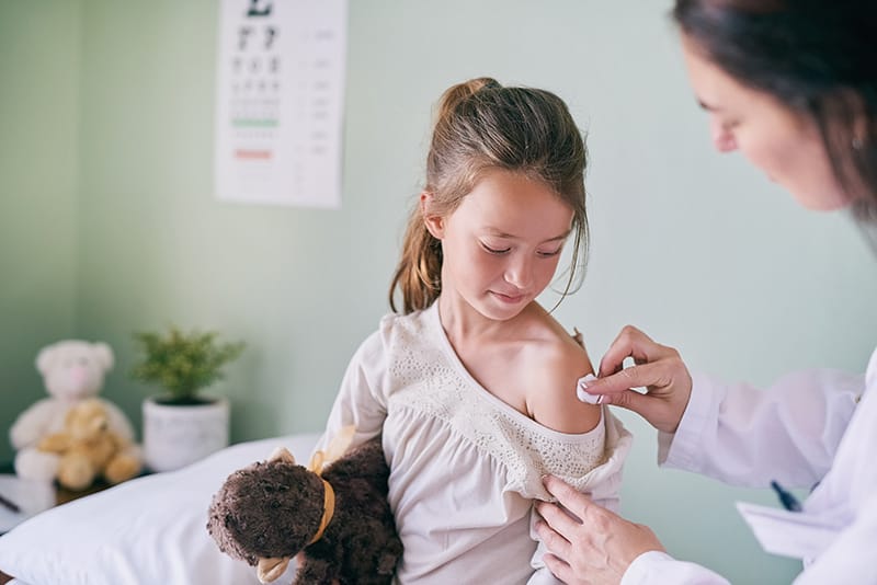 Child receiving a shot from a physician