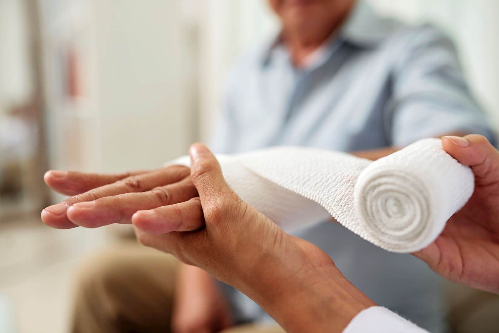 Doctor Wrapping Patients Hand In Bandage