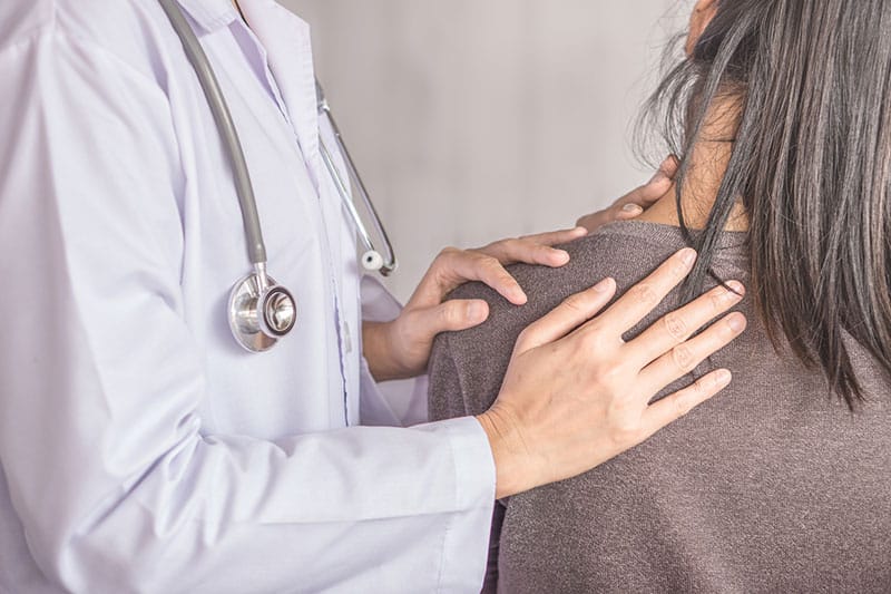 Doctor assessing a patient with neck pain