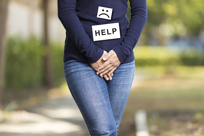 Women, standing with her legs crossed and a 'help' sign on her shirt