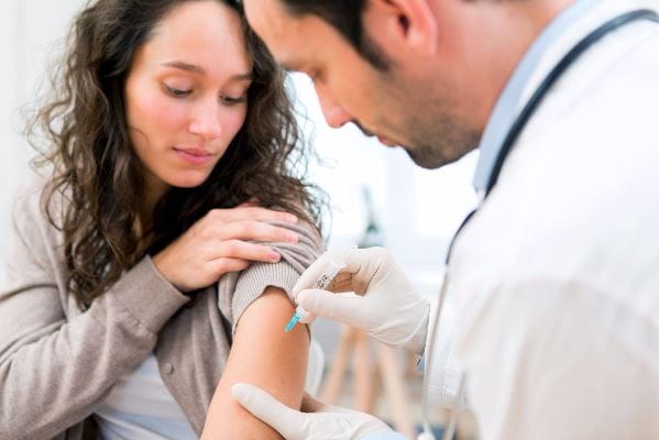 Woman receiving her flu shot from a medical provider