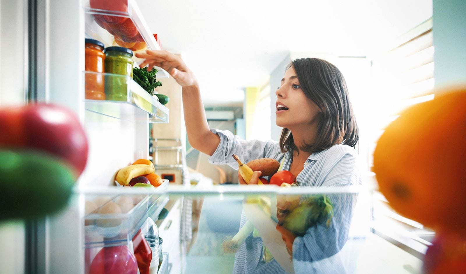 Women reaching in fridge for healthy meal