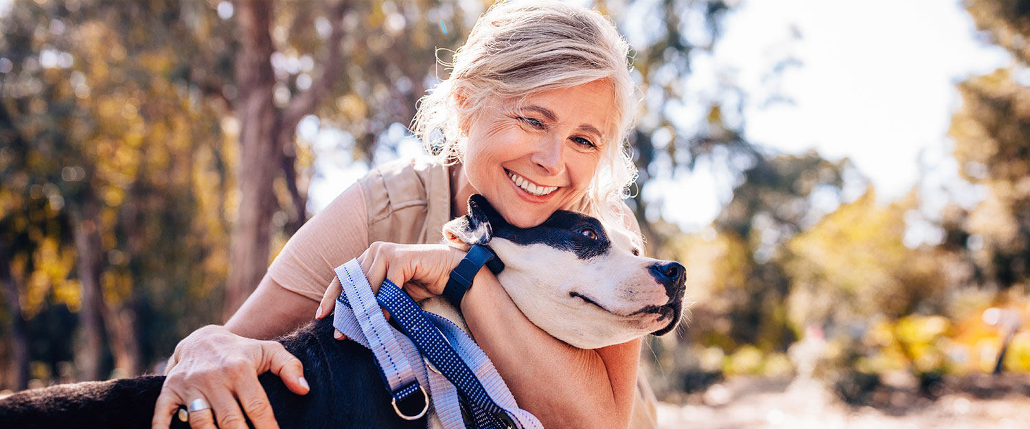 Woman hugging dog and smiling