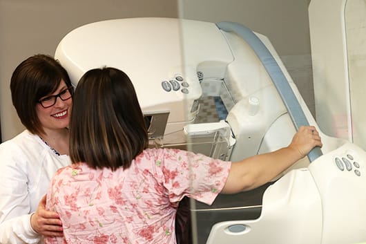 Tech and patient with 3D mammography machine
