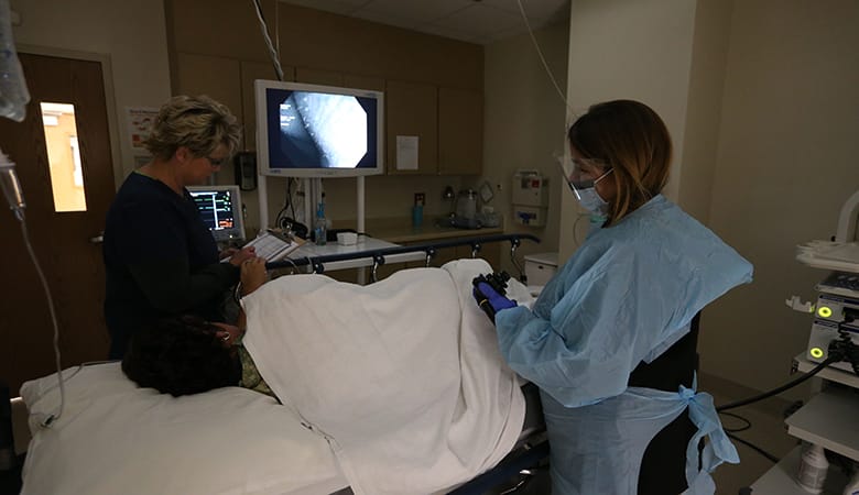 Endoscopy Center - procedure being performed by doctor and nurse is writing on checklist
